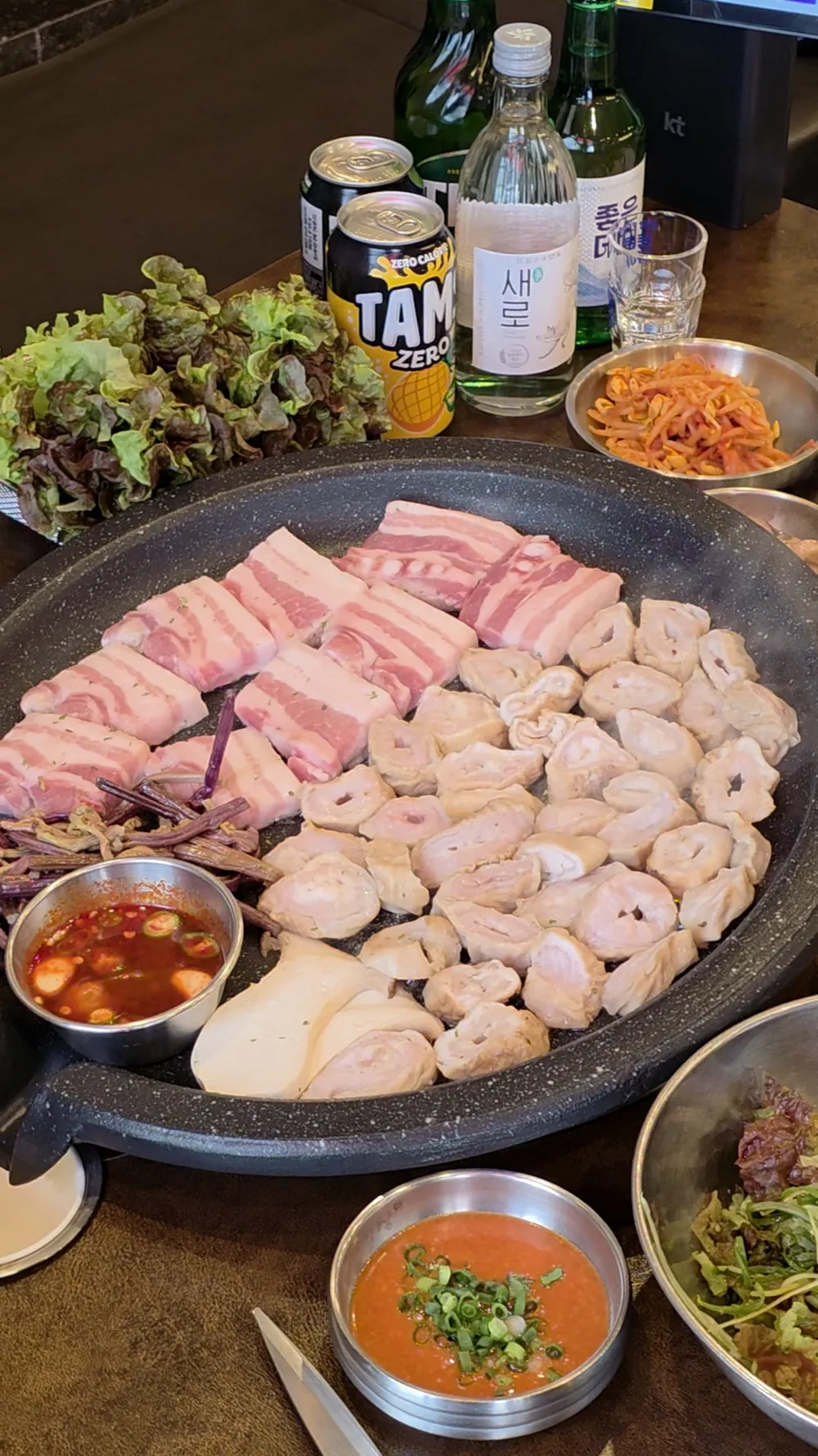 불판 위에 생삼겹살과 막창을 함께 올려 굽는 모습